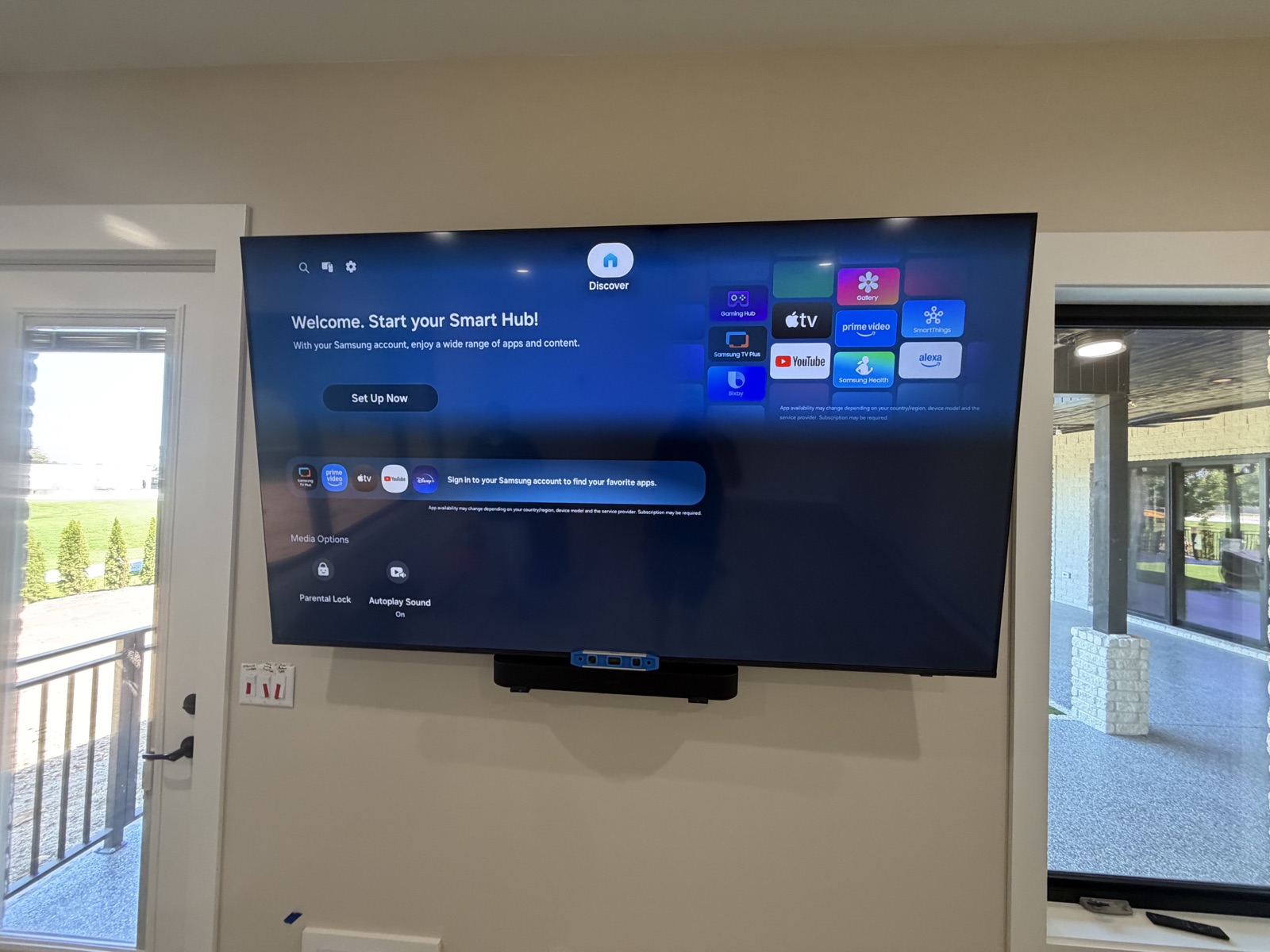 Wall-mounted TV between a door and a window