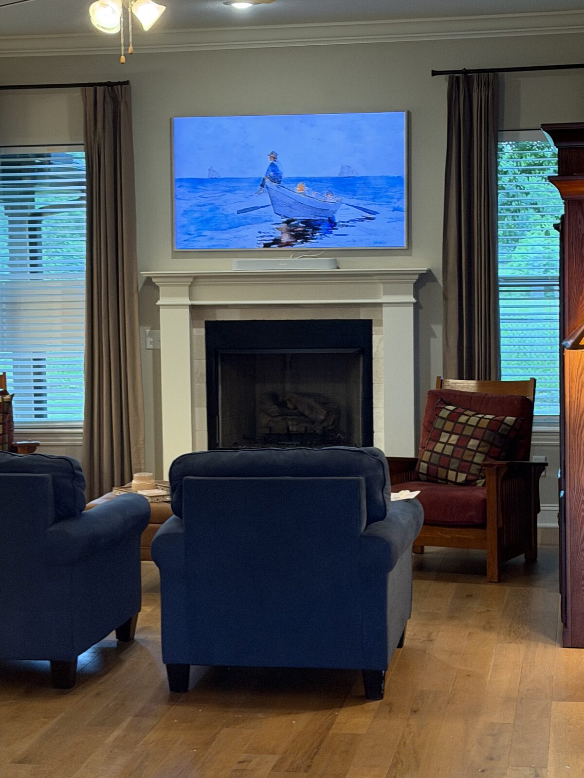 Wall-mounted Samsung Frame TV in art mode above a fireplace, with a soundbar mounted underneath and no visible cables.